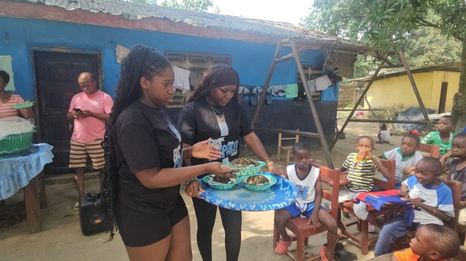 Alanna and Gizelle Cooper serving meals to children